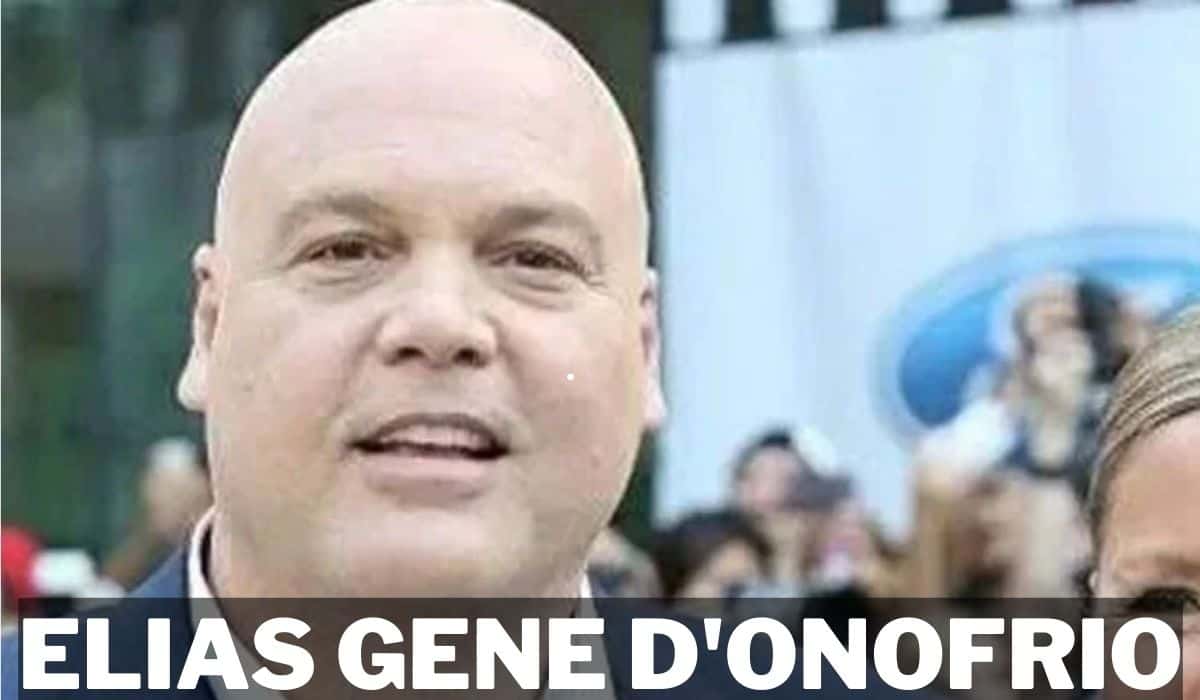 A black and white headshot of actor Elias Gene D'Onofrio. He has short, dark, curly hair and is looking off-camera with a thoughtful expression.